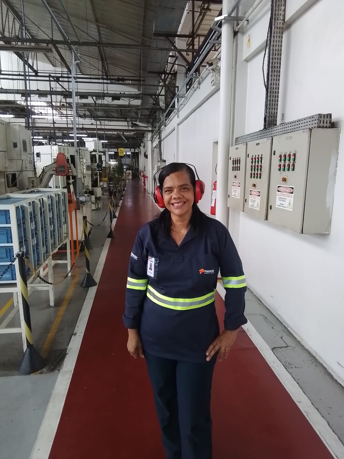 Colaboradora da Padrão Serviços em limpeza de corredor industrial