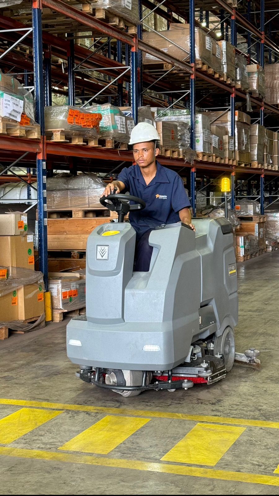 Colaborador da Padrão Serviços operando lavadora automatizada em galpão logístico